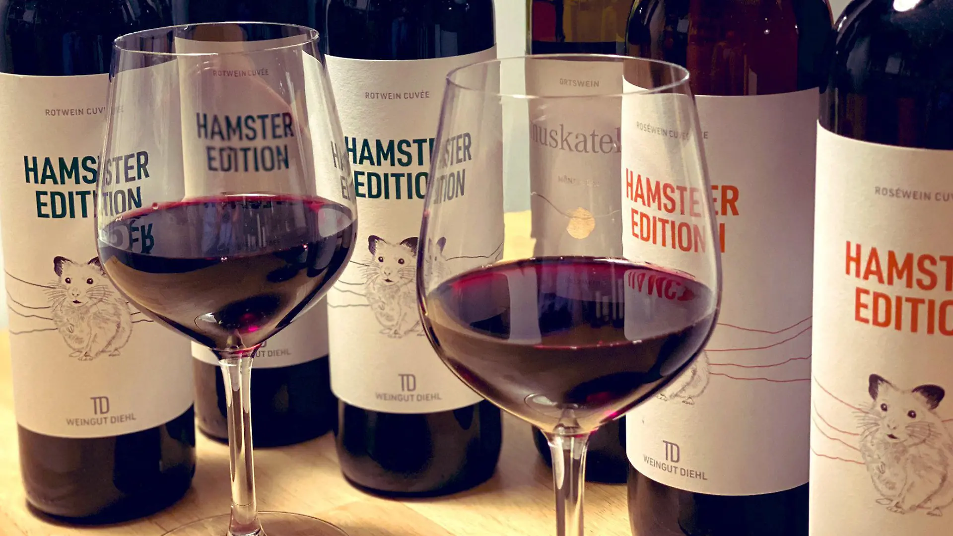 HANDOUT - 25.03.2020, Baden-Württemberg, Stuttgart: Zwei gefüllte Weingläser und Flaschen der «Hamster Edition» stehen auf einem Tisch beim Weingut Diehl. (zu dpa - Kreative Winzer-Ideen: Vom «Hamster-Wein» bis zum «Stillen Helden») Foto: Weingut Diehl/dpa - ACHTUNG: Nur zur redaktionellen Verwendung im Zusammenhang mit der aktuellen Berichterstattung und nur mit vollständiger Nennung des vorstehenden Credits +++ dpa-Bildfunk +++