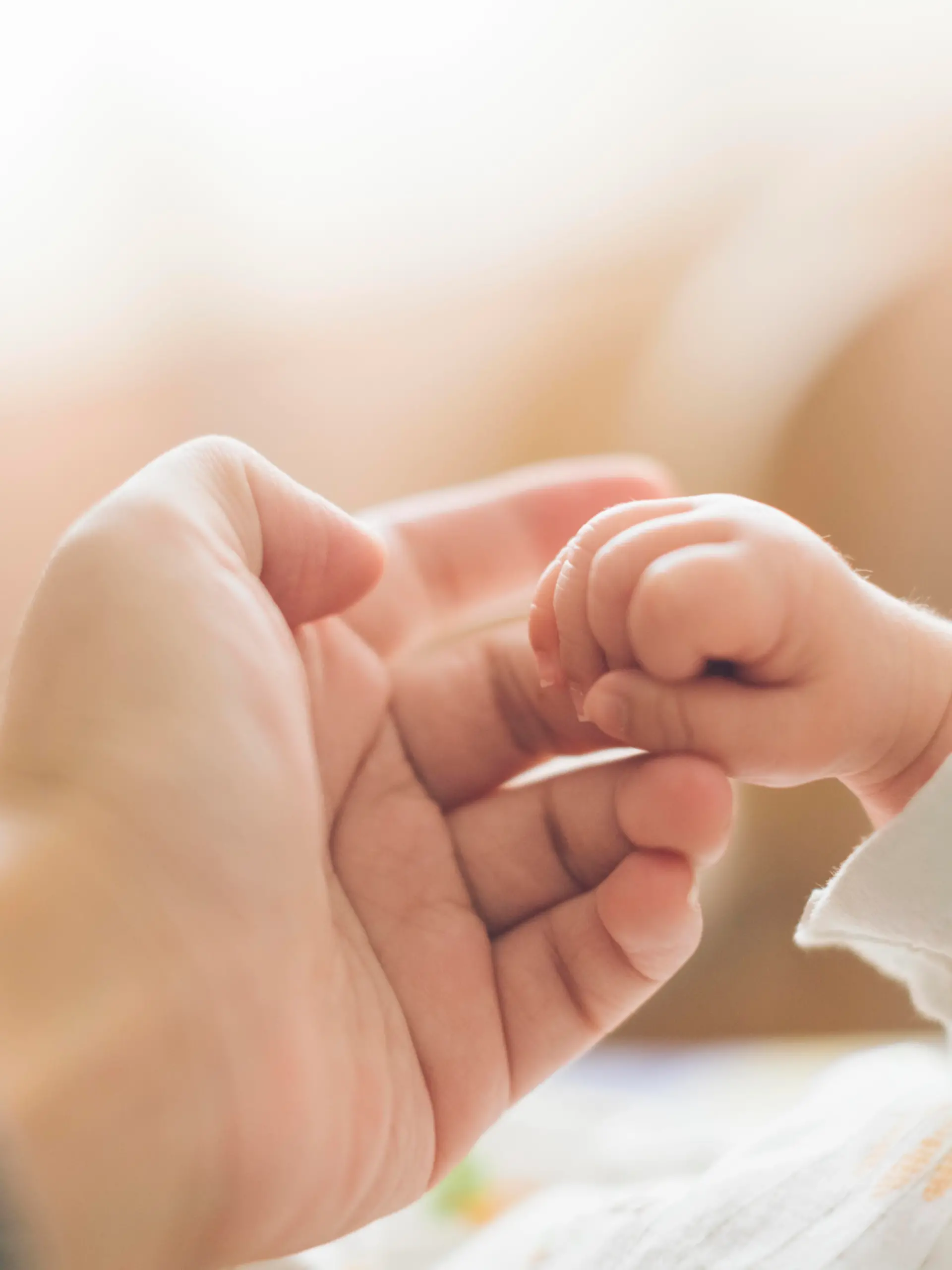 Baby ertastet den FInger des Vaters