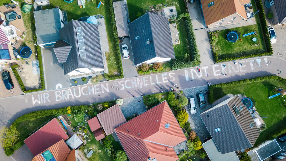 dpatopbilder - 05.05.2020, Niedersachsen, Weetzen: "Wir brauchen schnelles Internet!!" steht in großen Buchstaben aus Kreide im Wohngebiet Altes Bergfeld. (Aufnahme mit Drohne) Die Anwohner wollen mit der Aktion auf ihre langsame Internetverbindung aufmerksam machen, die gerade im Online-Unterricht, Homeoffice und bei Videokonferenzen zur Belastung wird. Der Großteil des Dorfes verfügt bereits seit längerem über einen Breitband-Internetzugang. Ausgangspunkt der Aktion war ein Sechstklässler, der in seinem Ärger über die langsame Internetverbindung einen Brief an die Telekom geschrieben hat - im Namen aller Kinder der Nachbarschaft. Foto: Ole Spata/dpa +++ dpa-Bildfunk +++