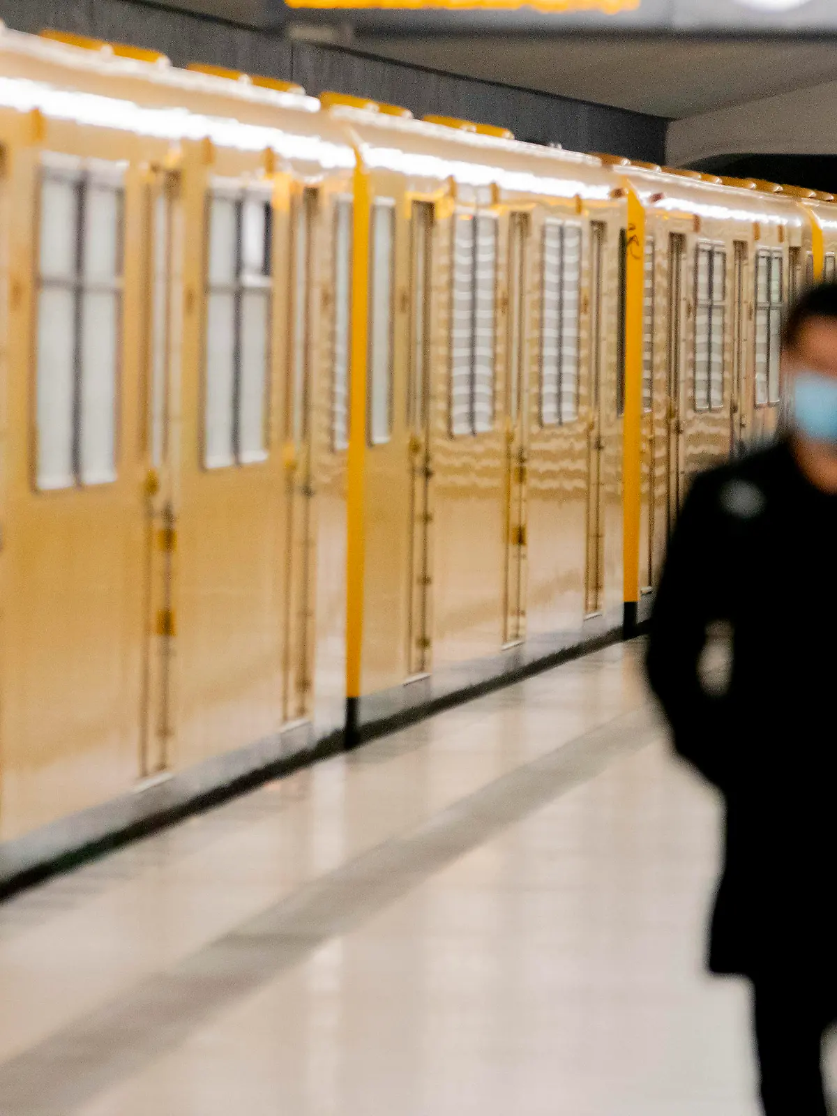 03.05.2020, Berlin: Ein Mann mit Mund-Nasen-Schutz läuft am U-Bahnhof Amrumer Straße auf dem Bahnsteig. Ab Montag kehrt die BVG in einem letzten von mehreren Schritten wieder komplett zum Regelfahrplan zurück. Foto: Christoph Soeder/dpa +++ dpa-Bildfunk +++