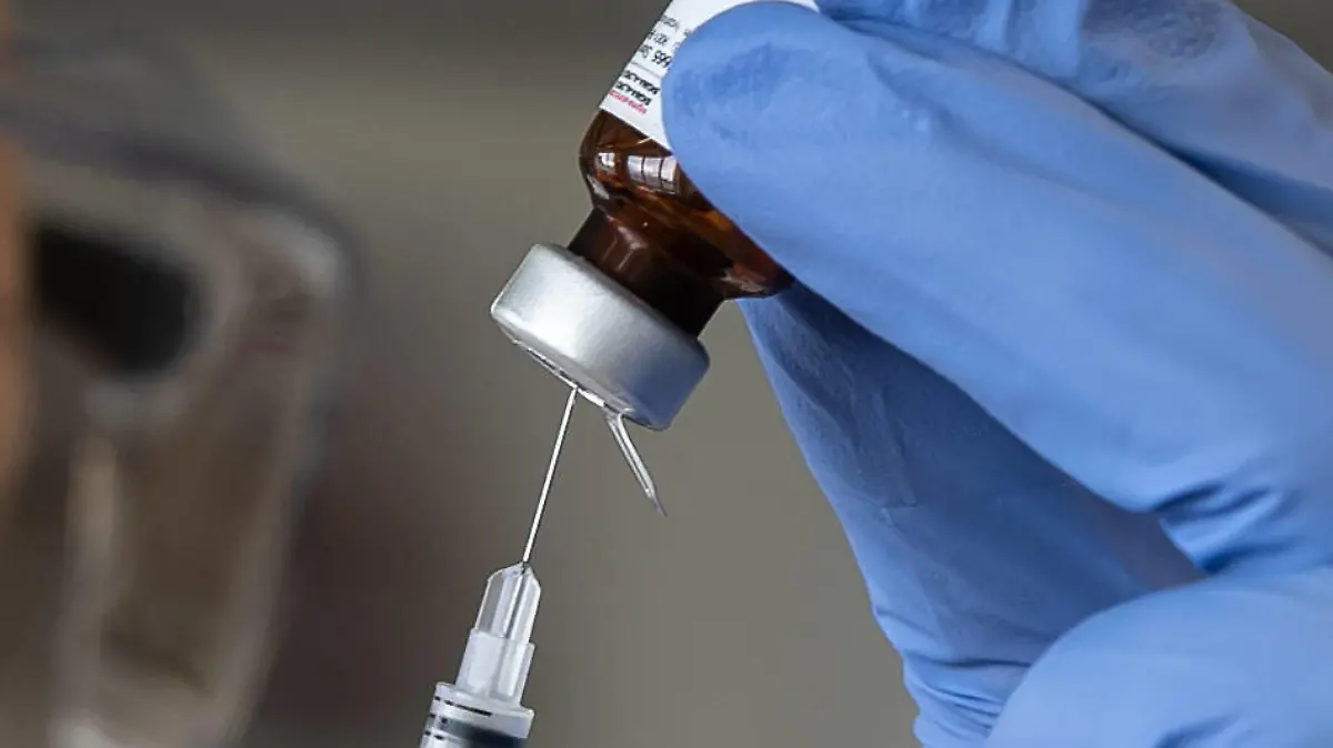  Hannover, Coronavirus, 29.04.2020, Ministerpräsident Stephan Weil und Minister Björn Thümler besuchen die Tierärztliche Hochschule in Hannover Präsident Dr. Gerhard Greif und weitere Wissenschaftler werden dort ihre Forschungen zur Entwicklung eines Impfstoffes gegen Corona vorstellen. Unter anderem geht es um Impfstoffentwicklung und Testung, Labor, SARS-CoV 2, Impfstoff, Spritze, impfen, Laborassistent in Schutzanzug und Maske mit Impfstoffampulle, Symbolfoto, *** Hanover, Coronavirus, 29 04 2020, Prime Minister Stephan Weil and Minister Björn Thümler visit the University of Veterinary Medicine in Hanover President Dr Gerhard Greif and other scientists will present their research on the development of a vaccine against corona. Among other things, they will talk about vaccine development and testing, laboratory, SARS CoV 2, va