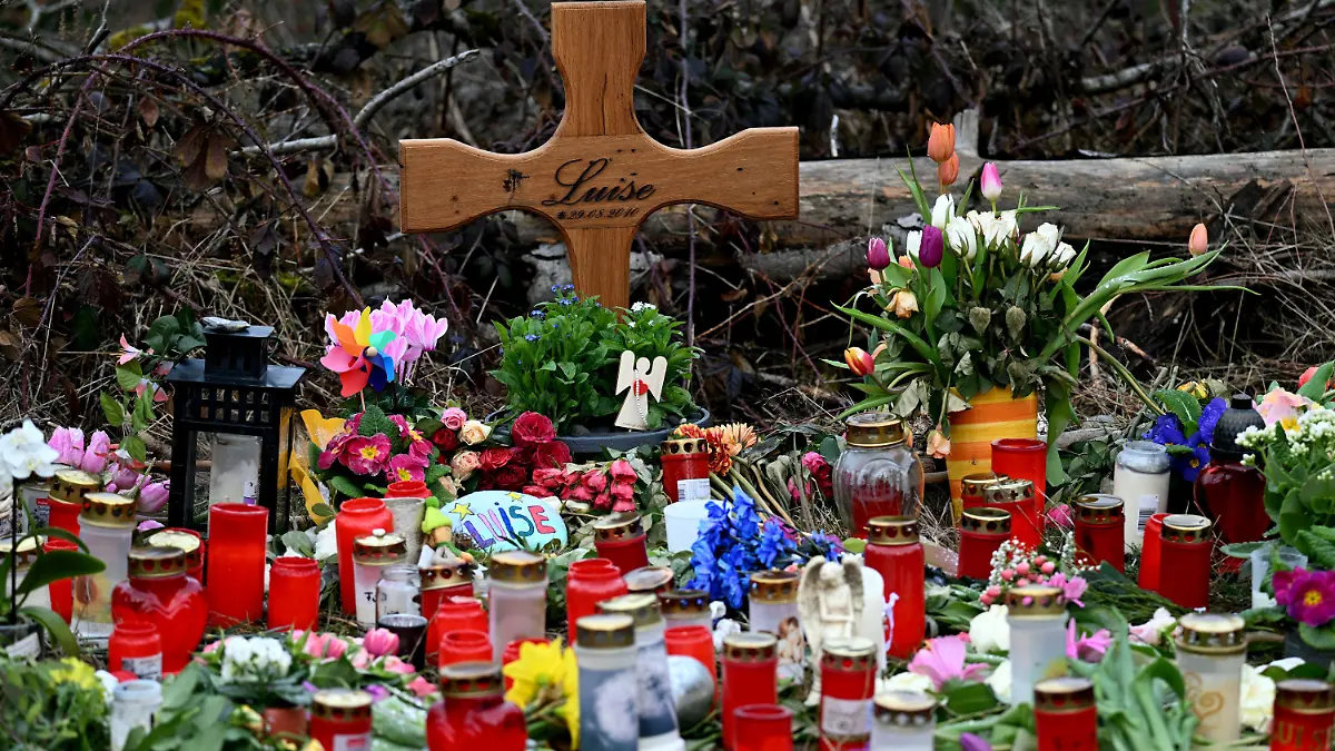 dpatopbilder - 22.03.2023, Nordrhein-Westfalen, Freudenberg: Ein Holzkreuz, zahlreiche Blumen, Kuscheltiere und Kerzen liegen am Tatort. Mit einer Trauerfeier nehmen Angehörige der getöteten zwölfjährigen Luise aus Freudenberg im Siegerland Abschied von dem Mädchen. Der gewaltsame Tod der Zwölfjährigen am 11. März hat viele Menschen geschockt. Zwei 12 und 13 Jahre alte Mädchen hatten gestanden, Luise mit Messerstichen getötet zu haben. Foto: Federico Gambarini/dpa +++ dpa-Bildfunk +++