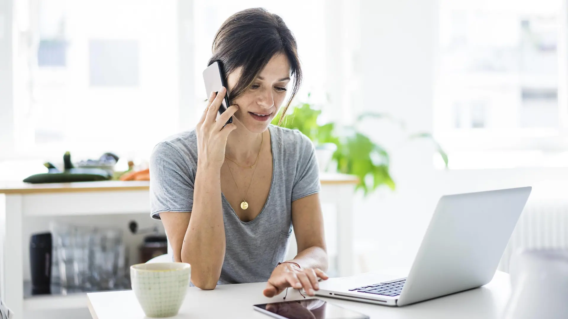 Happy oman sitting at desk, working from home, using laptop model released Symbolfoto property released PUBLICATIONxINxGERxSUIxAUTxHUNxONLY MOEF01820
