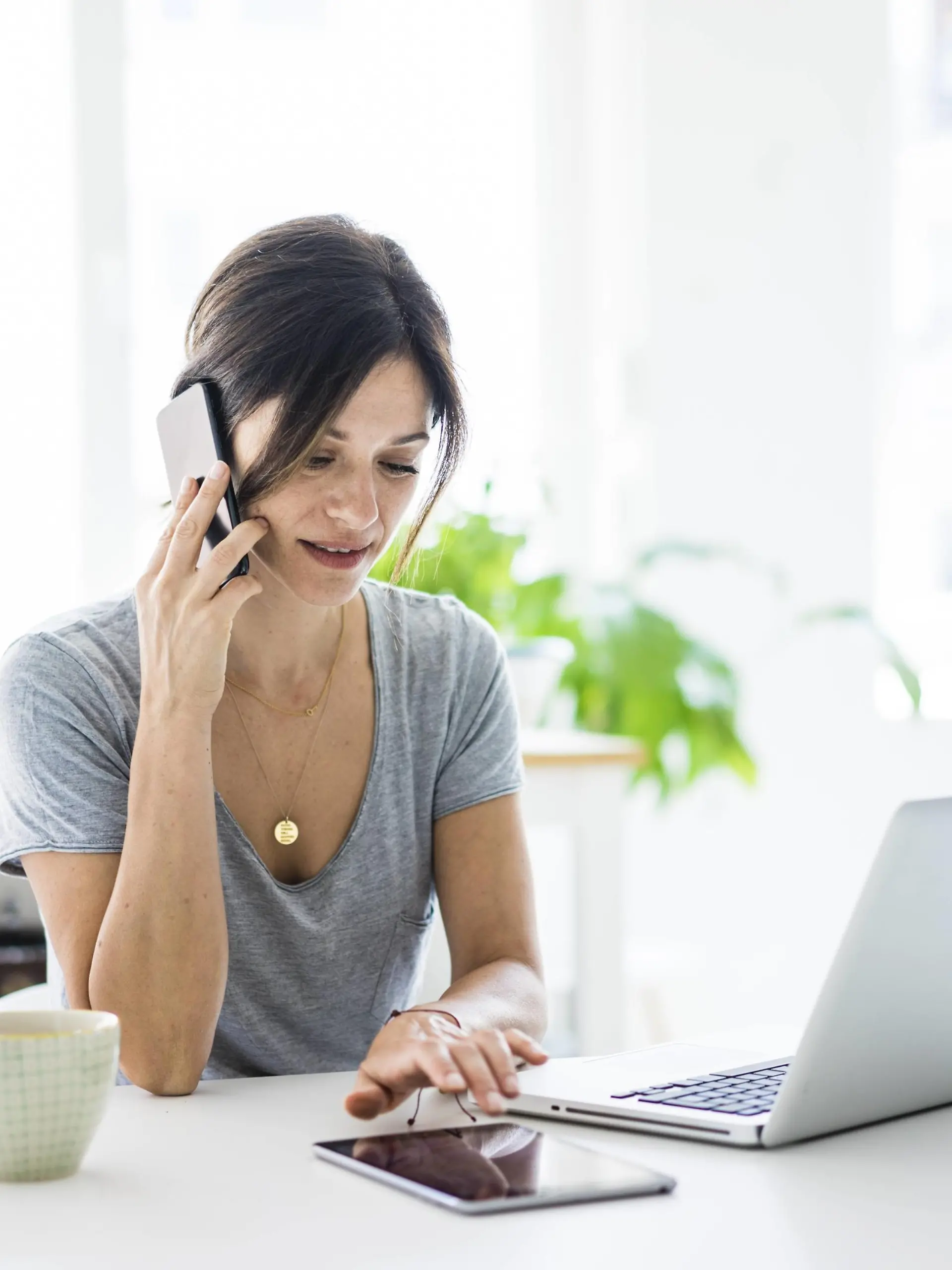 Happy oman sitting at desk, working from home, using laptop model released Symbolfoto property released PUBLICATIONxINxGERxSUIxAUTxHUNxONLY MOEF01820  