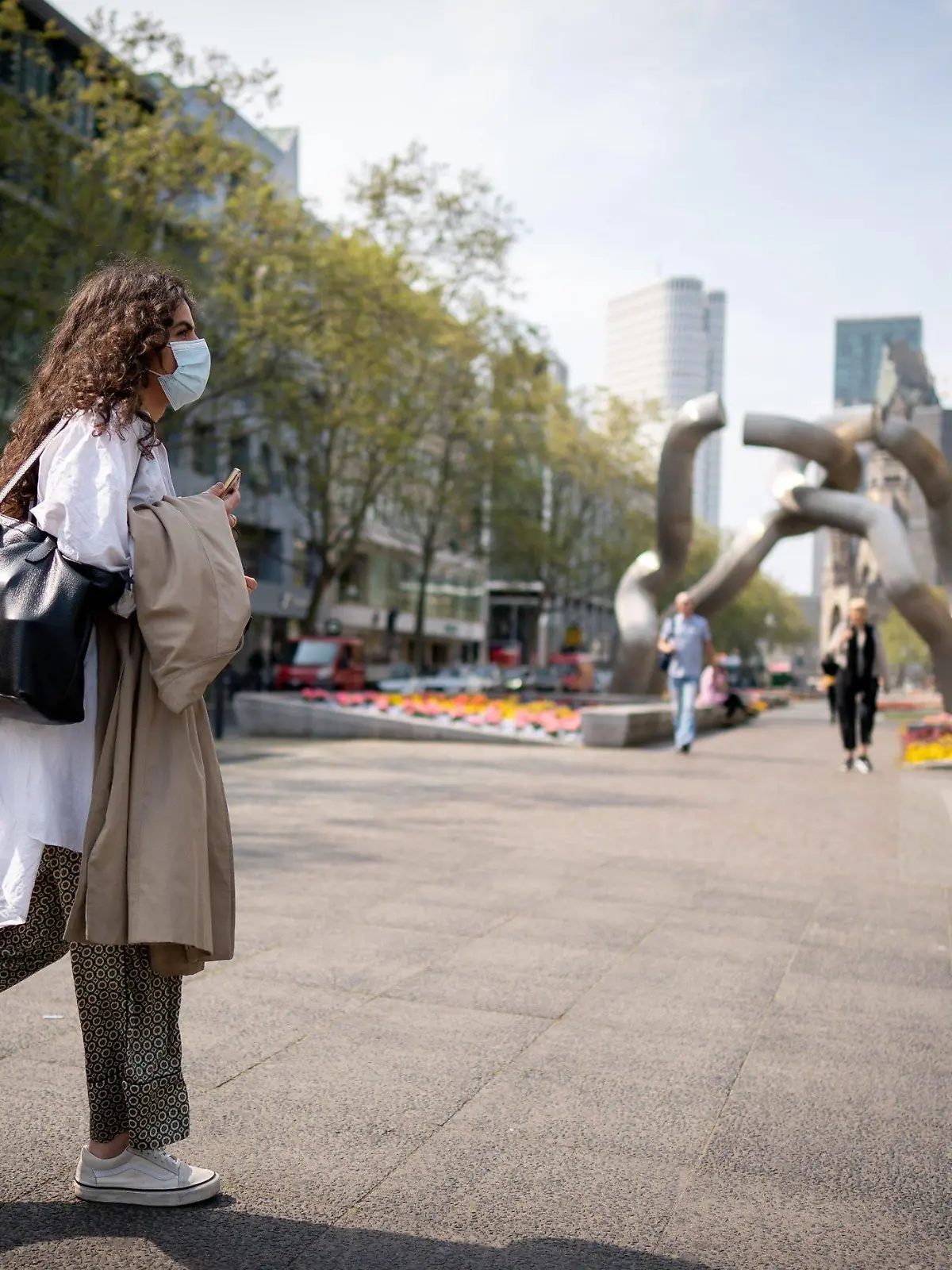 28.04.2020, Berlin: Eine Passantin mit Mund-Nasen-Schutz geht über den Kudamm. Als letztes Bundesland führt Berlin auch eine Maskenpflicht in Geschäften ein. Das hat der Berliner Senat beschlossen. Die Pflicht, beim Einkaufen einen Mund-Nasen-Schutz zu tragen, soll schon ab 29.04.2020 gelten. Foto: Kay Nietfeld/dpa +++ dpa-Bildfunk +++