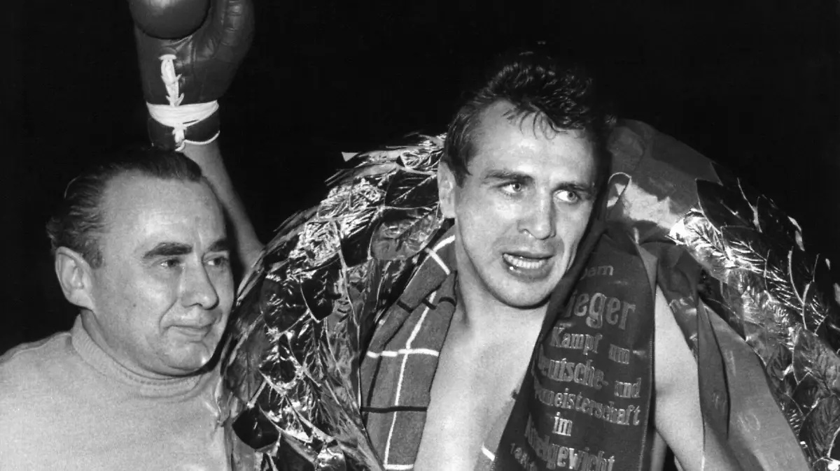 ARCHIV - 14.11.1959, Berlin: Siegreich reckt Gustav «Bubi» Scholz nach einem gewonnen Europameisterschaftskampf die Faust - neben ihm sein Trainer Lado Taubeneck. (zu dpa «Steiler Aufstieg, böser Absturz: Scholz - «Bubi», Star, Todesschütze» am 08.04.2020) Foto: Günther Bratke/dpa +++ dpa-Bildfunk +++