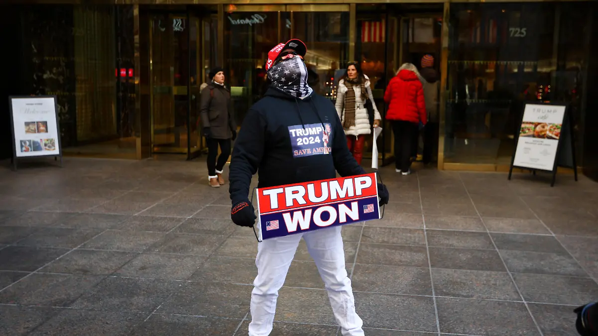 A man who identified himself as Don Cini, a supporter of former U.S. President Donald Trump, holds a Trump campaign sign outside Trump Tower in midtown Manhattan in New York City, New York, U.S., March 20, 2023. REUTERS/Mike Segar