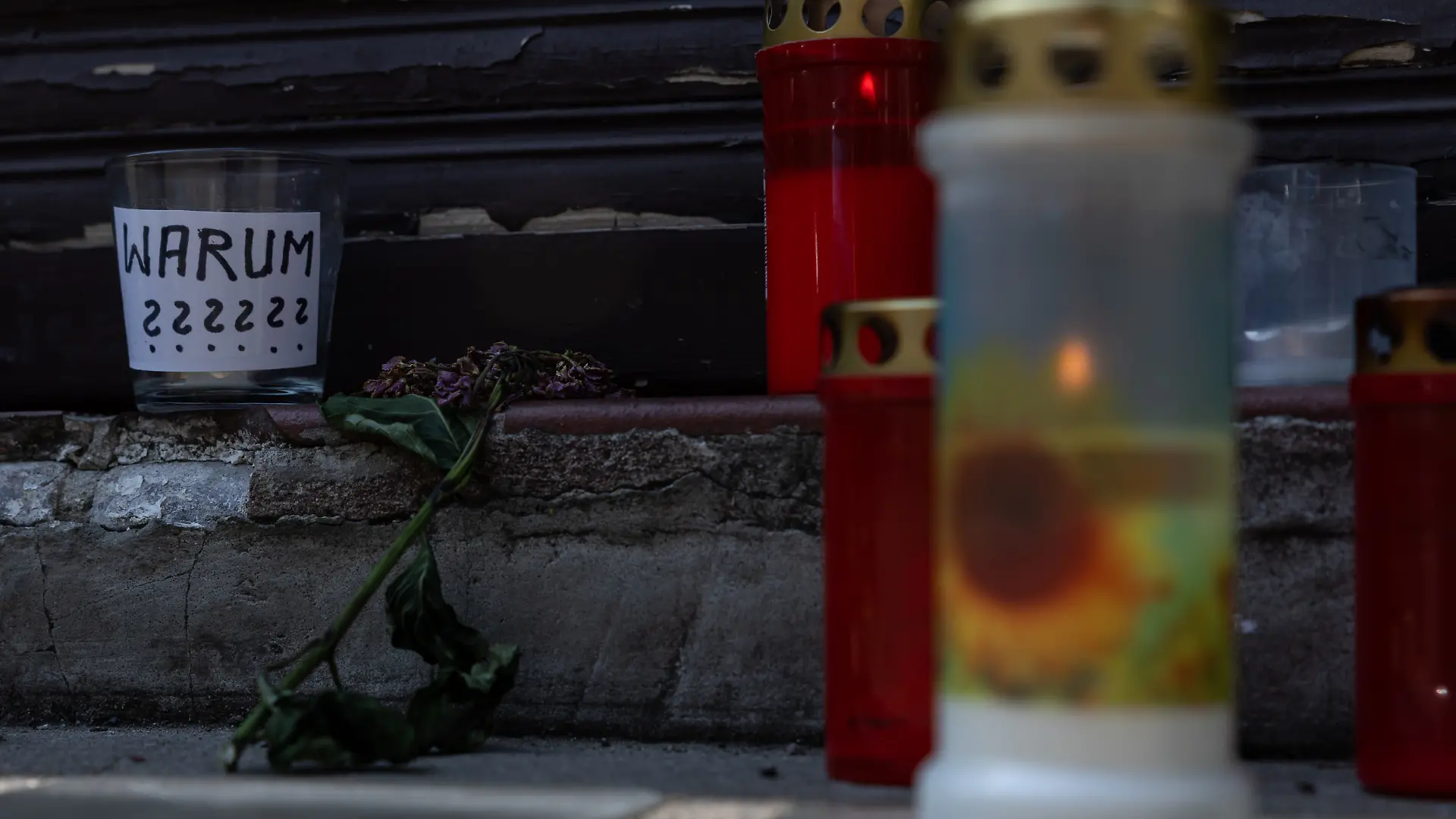 Kerzen und ein Glas mit der Aufschrift „Warum???“ stehen am Tatort nach dem mutmaßlichen Tötungsdelikt in einer Arztpraxis in Berlin-Wedding.