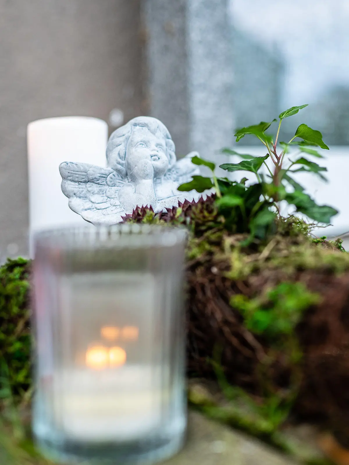 08.11.2019, Nordrhein-Westfalen, Detmold: Eine Engelsfigur steckt in einem Blumengesteck, das neben Kerzen an dem Mehrfamilienhaus abgelegt wurde, wo am Abend des 06.11.2019 eine 15-Jährige ihren dreijährigen Halbbruder in Detmold mit einem Messer getötet haben soll. Foto: Guido Kirchner/dpa +++ dpa-Bildfunk +++