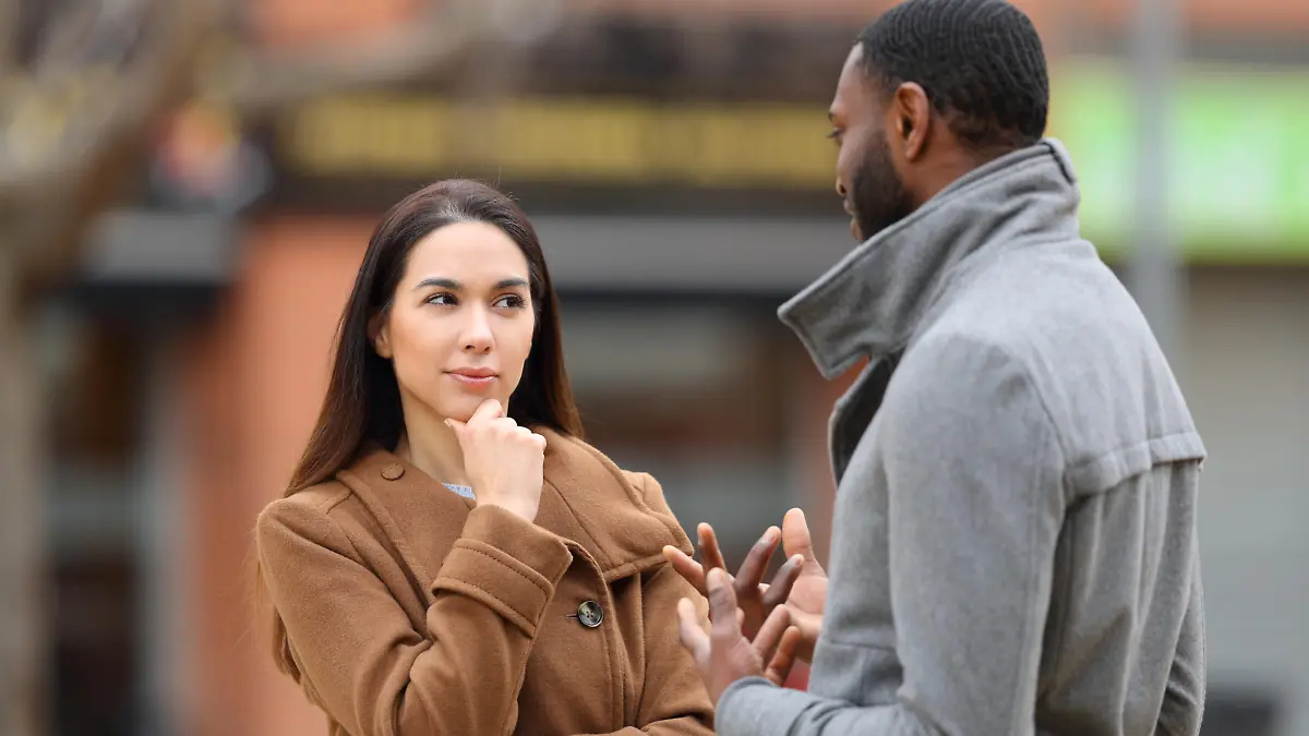Suspicious woman listening a man talking in the street, Suspicious woman listening a man talking in the street in winter, Suspicious woman listening a man talking in the street in winter model released, Symbolfoto , 02.01.2023, Copyright: xPheelingsMediax Panthermedia33405213.jpg
