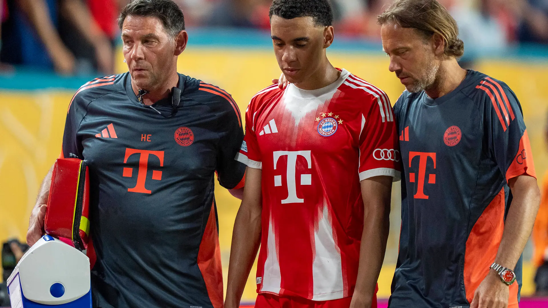 Jamal Musiala wird von den Ärzten des FC Bayern vom Platz begleitet