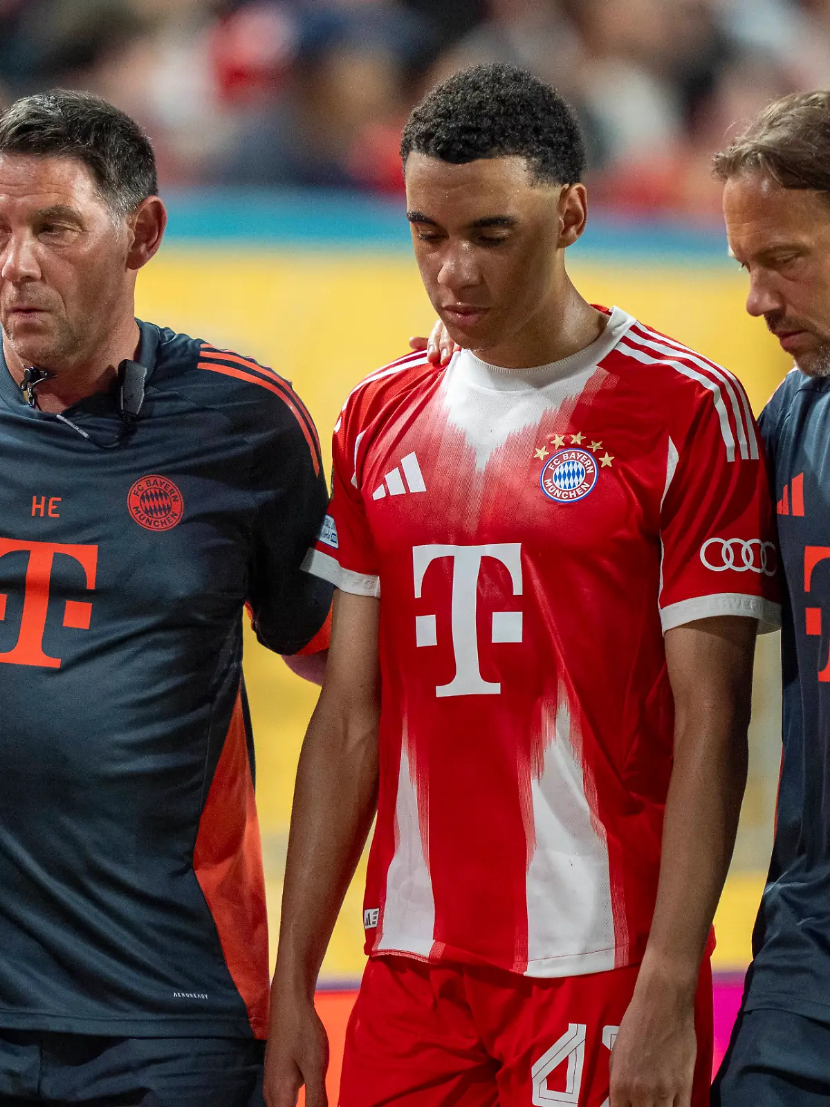 Jamal Musiala wird von den Ärzten des FC Bayern vom Platz begleitet
