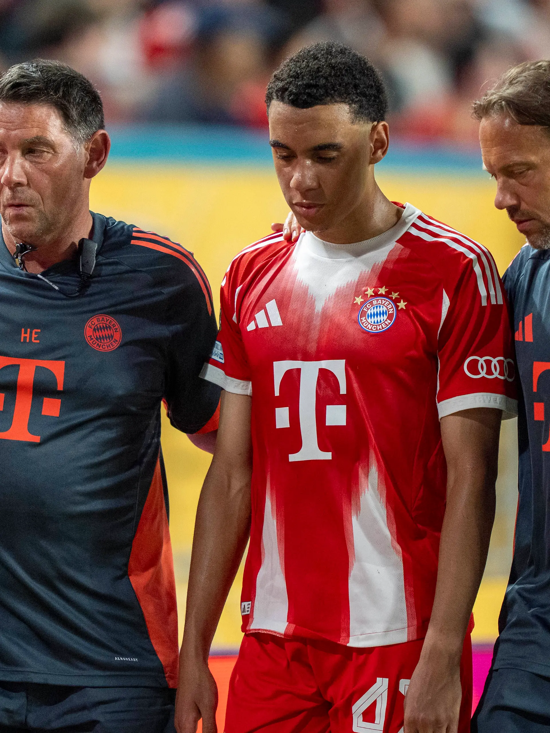 Jamal Musiala wird von den Ärzten des FC Bayern vom Platz begleitet