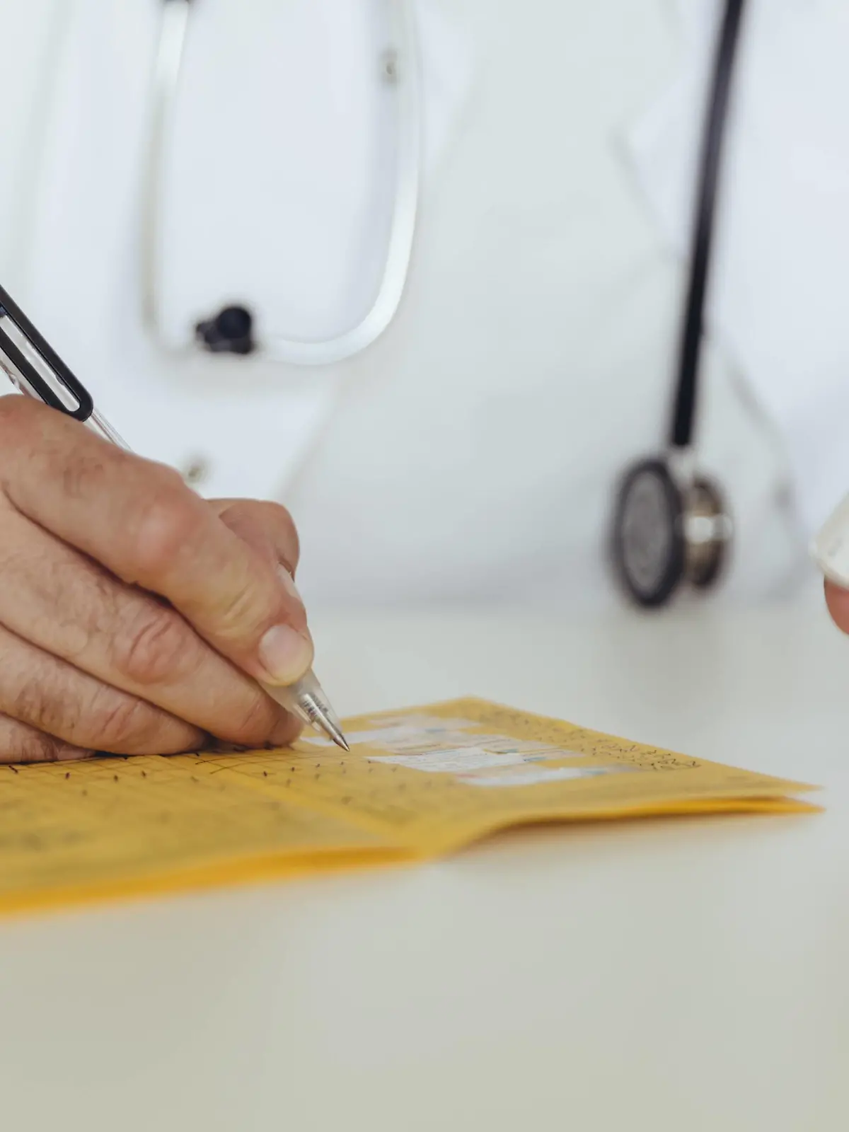 Doctor filling in immunization card model released Symbolfoto property released PUBLICATIONxINxGERxSUIxAUTxHUNxONLY MFF04478  