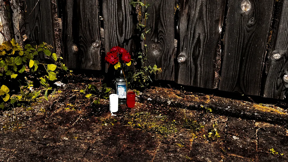 Blumen und Kerzen erinnern am Tatort an die Bluttat