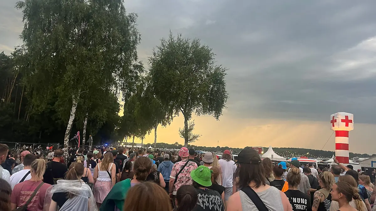 Menschen verlassen wegen einer Unwetterwarnung das Hurricane-Festival