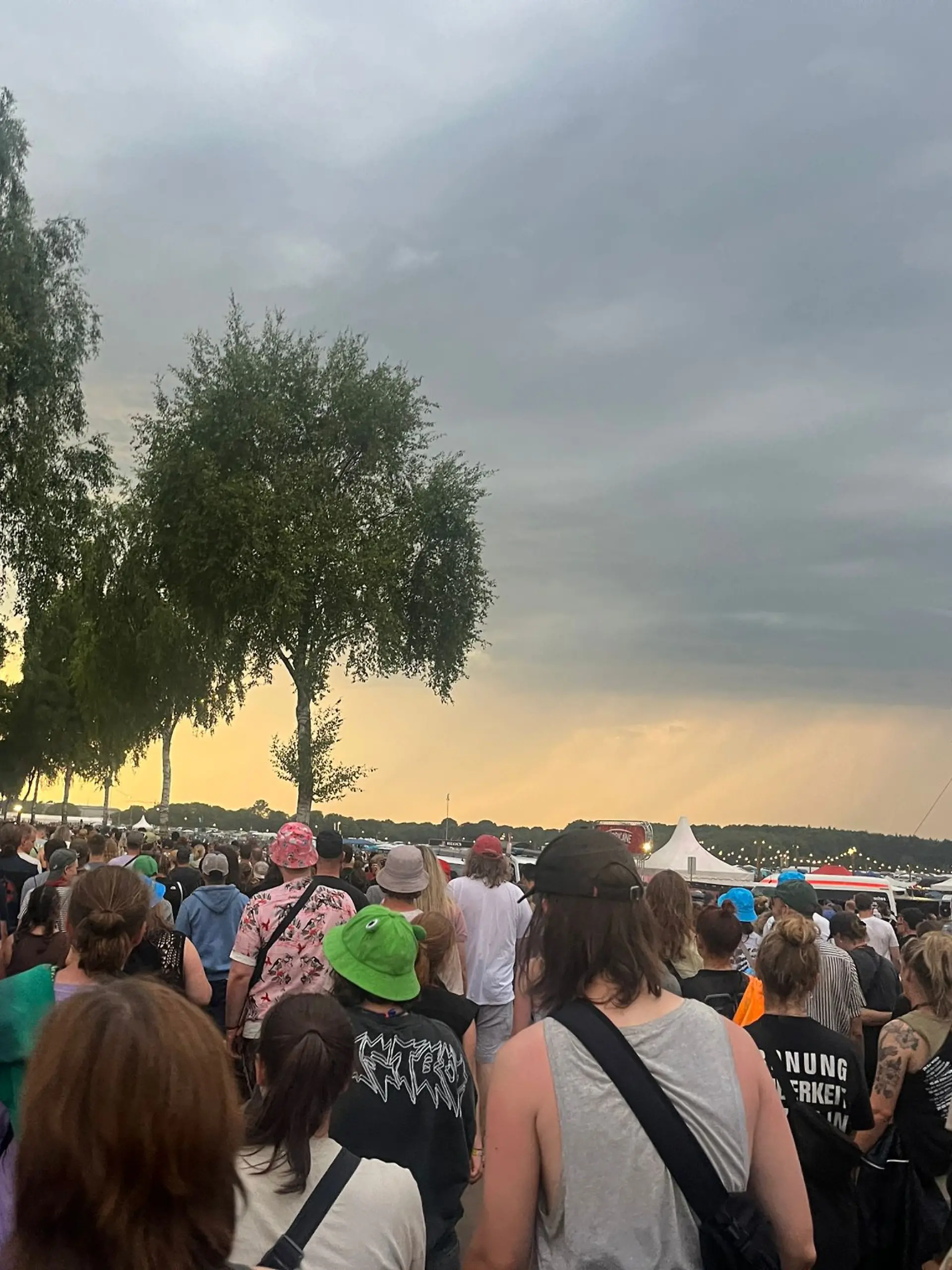 Menschen verlassen wegen einer Unwetterwarnung das Hurricane-Festival