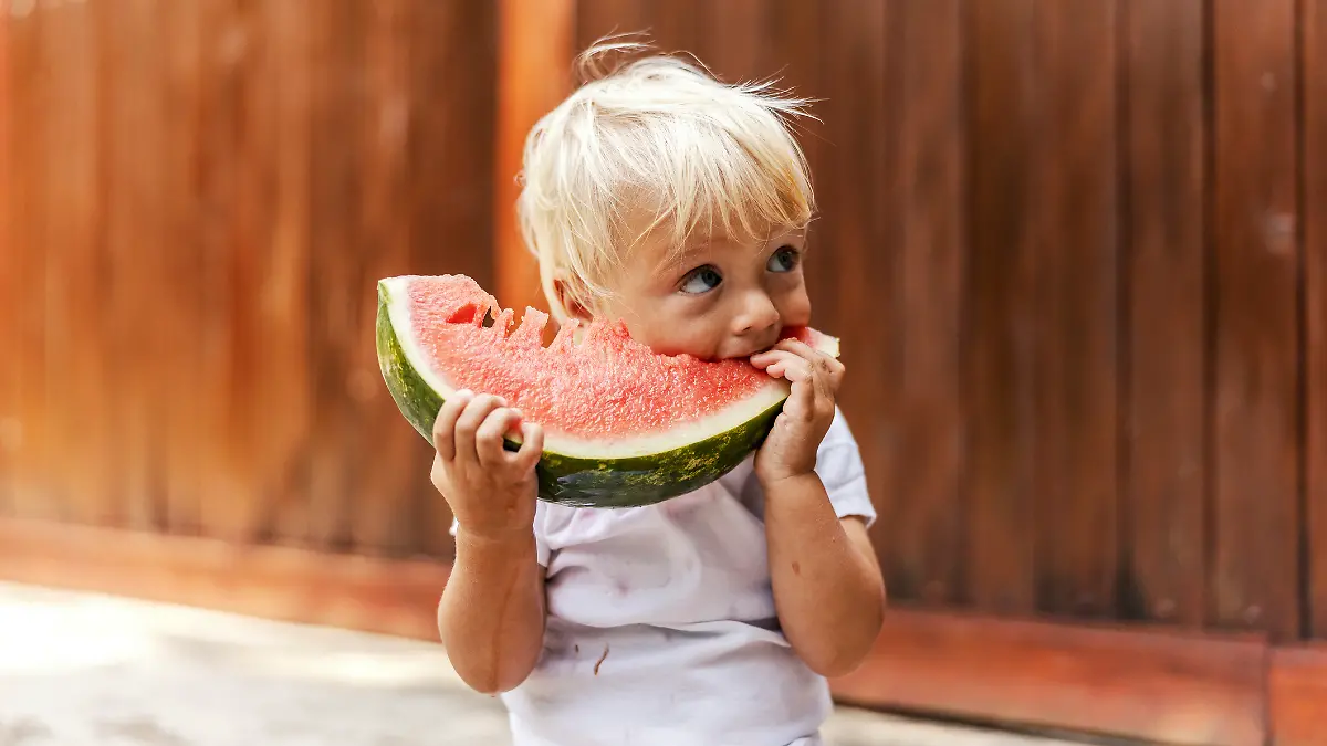 Ein kleiner Junge genießt seine Wassermelone.