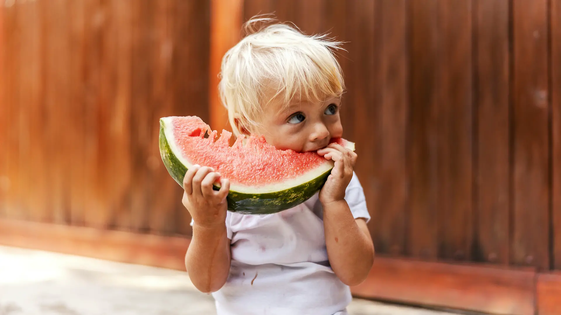 Ein kleiner Junge genießt seine Wassermelone.