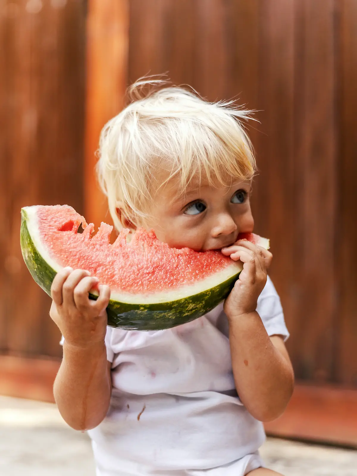 Ein kleiner Junge genießt seine Wassermelone.