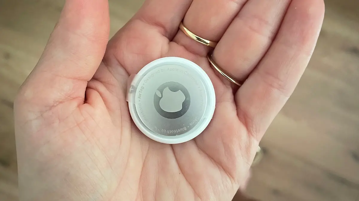 Airtag von Apple auf der Handinnenfläsche.