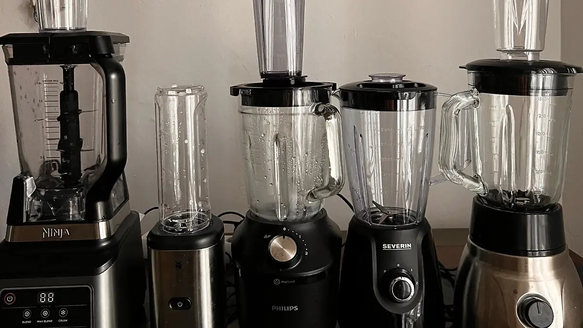 Fünf verschiedene Standmixer nebeneinander aufgereiht – vier Modelle mit To-Go-Flasche, ein Gerät ohne