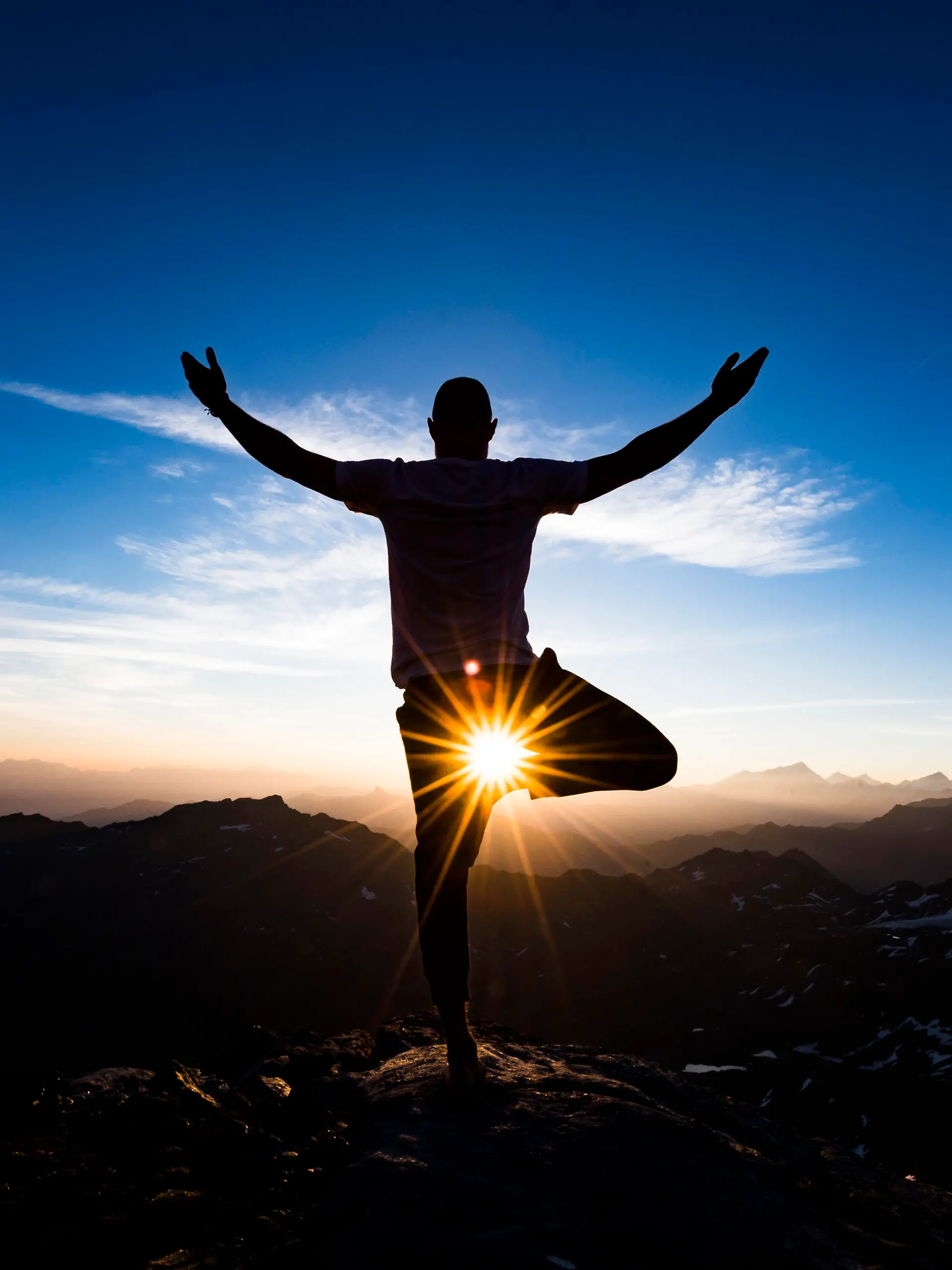 ARCHIV - 02.08.2018, Schweiz, Verbier: Emilien Badoux, Schweizer Ski- und Yogalehrer, praktiziert Yoga bei Sonnenaufgang auf dem Gipfel des Mont Fort (3329 Meter über dem Meeresspiegel), umgeben von Schweizer Alpen. Yoga ist groß in Mode. Sport- und Bekleidungsindustrie überlegen, wie sich der Trend zu Geld machen lässt. (zu dpa "Vom BH bis zum Handtuch - Produkte für den Yogi" vom 01.02.2019) Foto: Jean-Christophe Bott/KEYSTONE/dpa +++ dpa-Bildfunk +++
