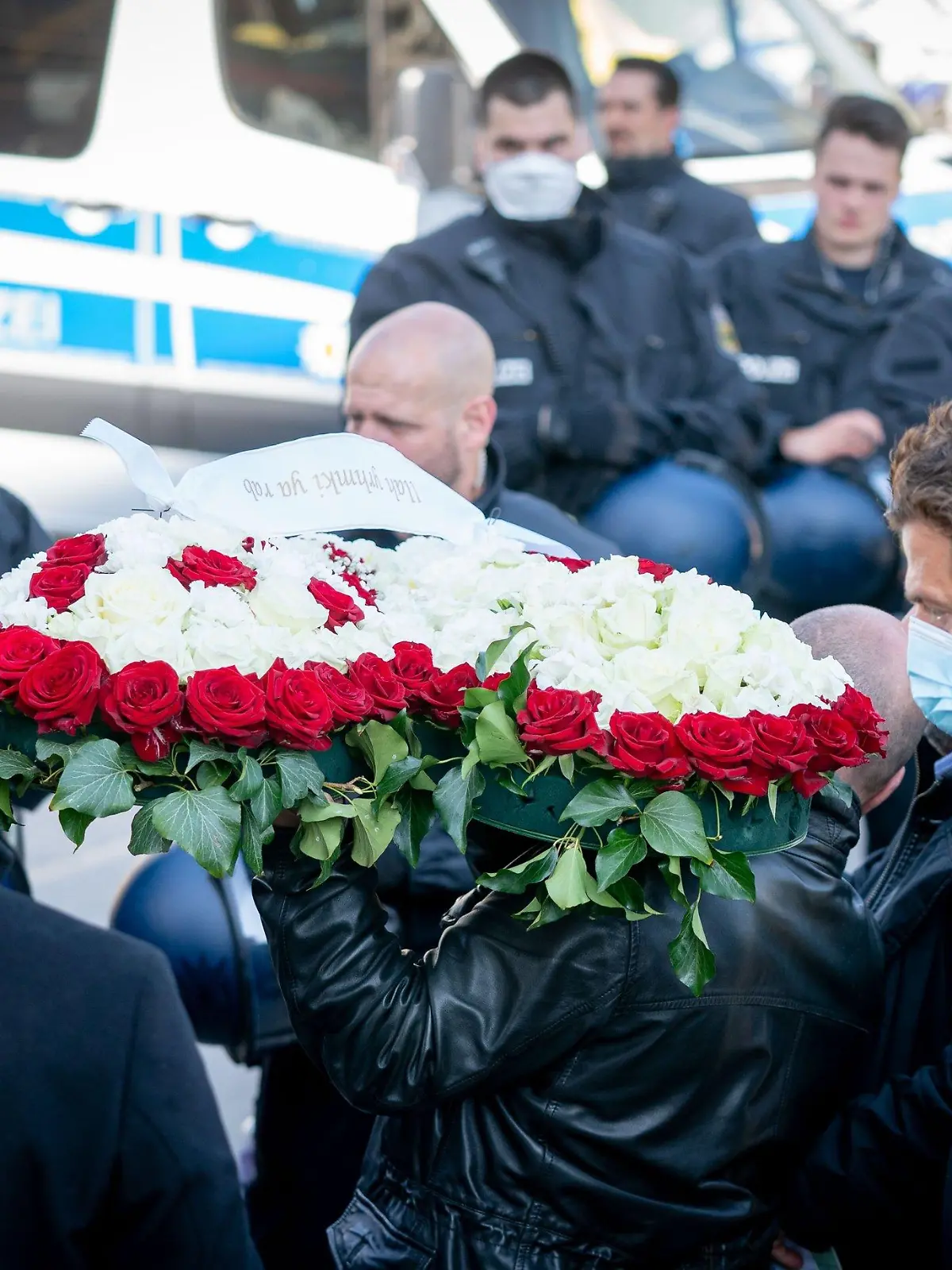 27.04.2020, Berlin: Trauernde stehen an einer Polizeiabsperrung im Berliner Stadtteil Schöneberg. Wegen einer Beerdigung im Clan-Milieu kam es zu einem großen Polizeieinsatz in dem Bezirk Tempelhof-Schöneberg. Um dabei die Corona-Regeln durchzusetzen, waren mehrere hundert Polizisten im Einsatz. Foto: Kay Nietfeld/dpa +++ dpa-Bildfunk +++
