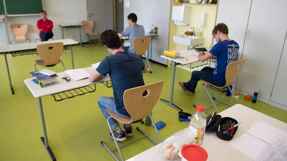 24.04.2020, Sachsen, Dresden: Schüler des Gymnasium Dresden-Klotzsche sitzen während der schriftlichen Abiturprüfung im Fach Physik in einem Klassenzimmer. Nach einer mehrwöchigen Corona-Zwangspause sind die Abschlussklassen wieder an den Schulen für ihre Prüfungen. Foto: Sebastian Kahnert/dpa-Zentralbild/dpa +++ dpa-Bildfunk +++