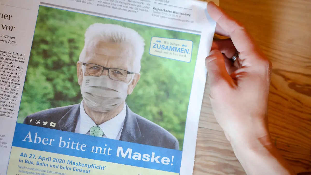 25.04.2020, Baden-Württemberg, Stuttgart: In der Stuttgarter Zeitung ist eine Anzeige der Landesregierung zu sehen, in der Ministerpräsident Winfried Kretschmann (Bündnis 90/Die Grünen) für das Tragen eines Mundschutzes wirbt.  (zu dpa: "Kretschmann wirbt für die Maske") Foto: Christoph Schmidt/dpa - ACHTUNG: Nur zur redaktionellen Verwendung im Zusammenhang mit der aktuellen Berichterstattung Kretschmann wirbt per Zeitungsanzeige für Maske +++ dpa-Bildfunk +++