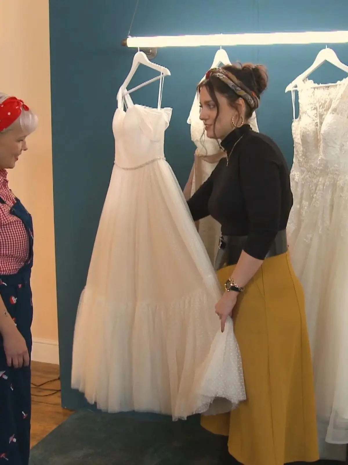 Bild zu: "Elaine startet mit der Präsentation ihrer Kleider"