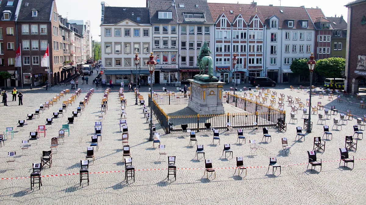 24.04.2020, Nordrhein-Westfalen, Düsseldorf: Leere Stühle stehen vor dem Rathaus und umgeben das Jan-Wellem-Denkmal. Düsseldorfer Gastronomen wollen hier mit einer Mahnwache auf ihre wirtschaftlichen Probleme aufmerksam machen. Foto: Rolf Vennenbernd/dpa +++ dpa-Bildfunk +++