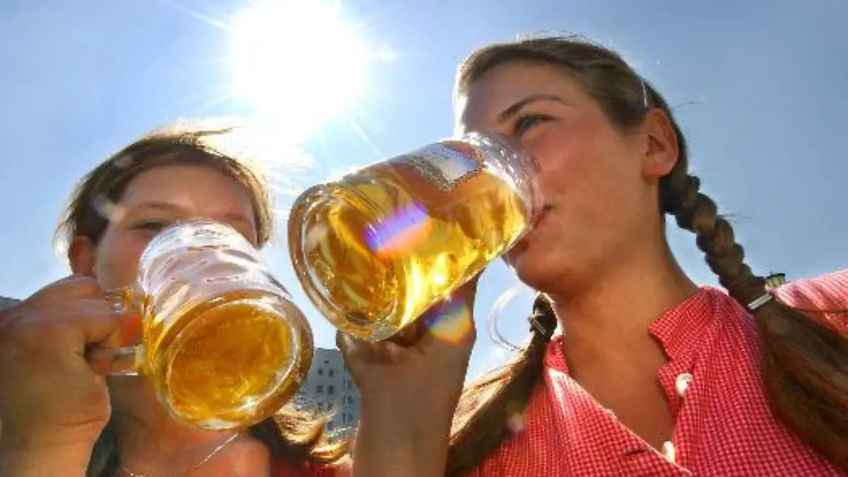 Mit kühlem Bier erfrischen sich zwei junge Frauen am Freitag (06.08.2004) bei strahlendem Sonnenschein in Berlin zur Eröffnung des Internationalen Bierfestivals. Das hochsommerliche Wetter mit Temperaturen bis über 30 Grad soll auch in den kommenden Tagen andauern. Das Sommerwetter wird wohl auch etliche Besucher zur traditionellen Biermeile ziehen, bei der am Wochenende auf etwa zwei Kilometern Länge rund 240 Brauereien ihre Biere anbieten. Foto: Stephanie Pilick dpa/lbn