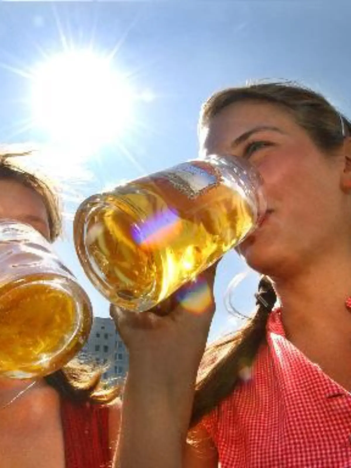Mit kühlem Bier erfrischen sich zwei junge Frauen am Freitag (06.08.2004) bei strahlendem Sonnenschein in Berlin zur Eröffnung des Internationalen Bierfestivals. Das hochsommerliche Wetter mit Temperaturen bis über 30 Grad soll auch in den kommenden Tagen andauern. Das Sommerwetter wird wohl auch etliche Besucher zur traditionellen Biermeile ziehen, bei der am Wochenende auf etwa zwei Kilometern Länge rund 240 Brauereien ihre Biere anbieten. Foto: Stephanie Pilick dpa/lbn