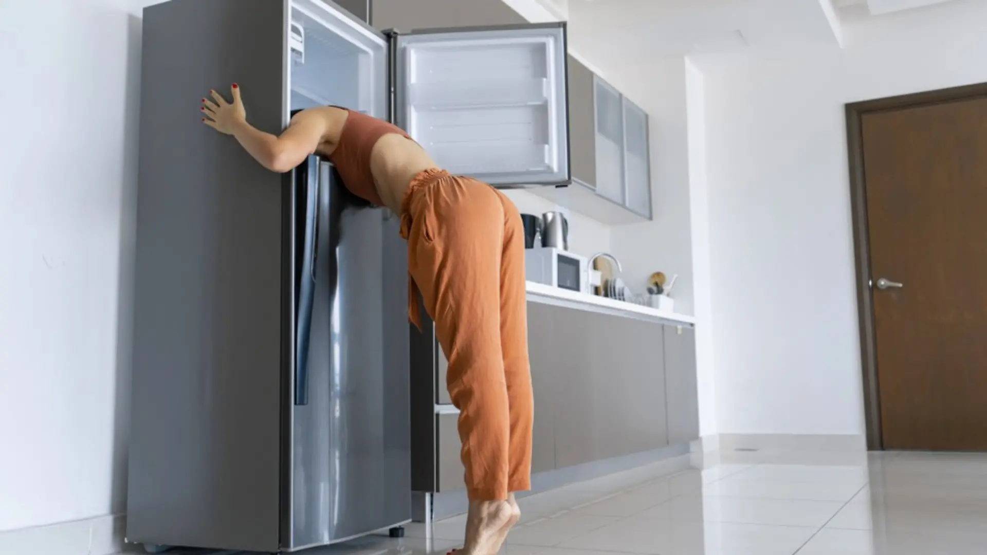 Eine Frau kühlt sich im Kühlschrank ab.