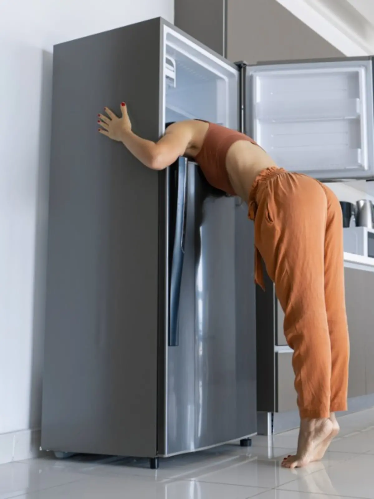 Eine Frau kühlt sich im Kühlschrank ab.