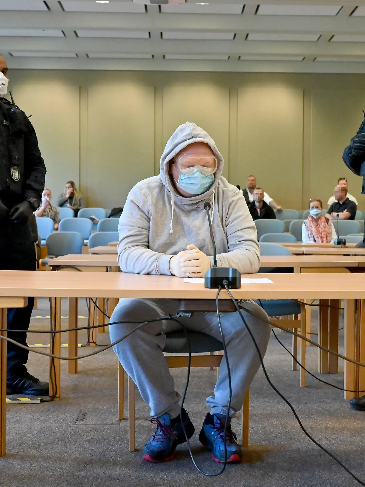 23.04.2020, Schleswig-Holstein, Schleswig: Mit Schutzbrille und Mundschutz sitzt der 47-Jährige Angeklagte beim Auftakt des Verfahrens im Gerichtssaal. Er soll die 23-Jährige Nathalie M., die sexuelle Dienstleistungen im Internet angeboten haben soll, am 17.8.2019 bei Schafflund getötet und an einem Feldweg bei Süderlügum verscharrt haben. Die Leiche wurde zwei Wochen später gefunden. Foto: Carsten Rehder/dpa - ACHTUNG: Personen wurden aus rechtlichen Gründen gepixelt +++ dpa-Bildfunk +++