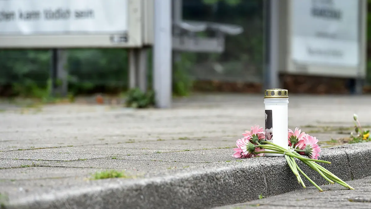 19.04.2020, Nordrhein-Westfalen, Essen: Eine Kerze und Blumen liegen an einer Haltestelle an der in der Nacht ein 14 Jahre alter Junge erstochen wurde. Der Jugendliche erlag im Krankenhaus seinen Verletzungen, wie Polizei und Staatsanwaltschaft am Sonntag mitteilten. Beamte nahmen einen 17-jährigen Tatverdächtigen vorläufig fest Foto: Caroline Seidel/dpa +++ dpa-Bildfunk +++