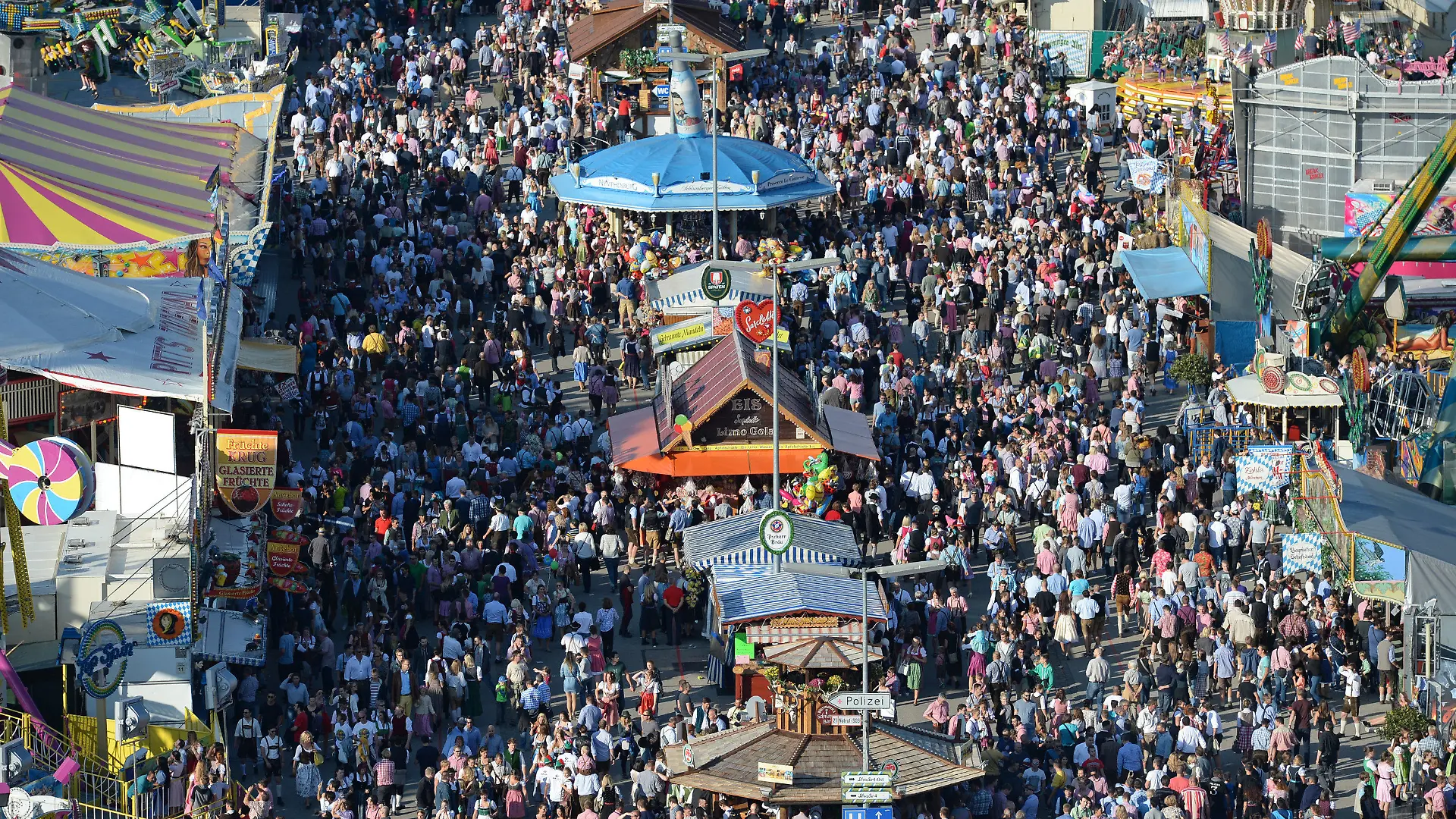 ARCHIV - 24.09.2016, Bayern, München: Zahlreiche Menschen gehen bei Sonnenschein über das Oktoberfest-Gelände. Foto: picture alliance / dpa +++ dpa-Bildfunk +++
