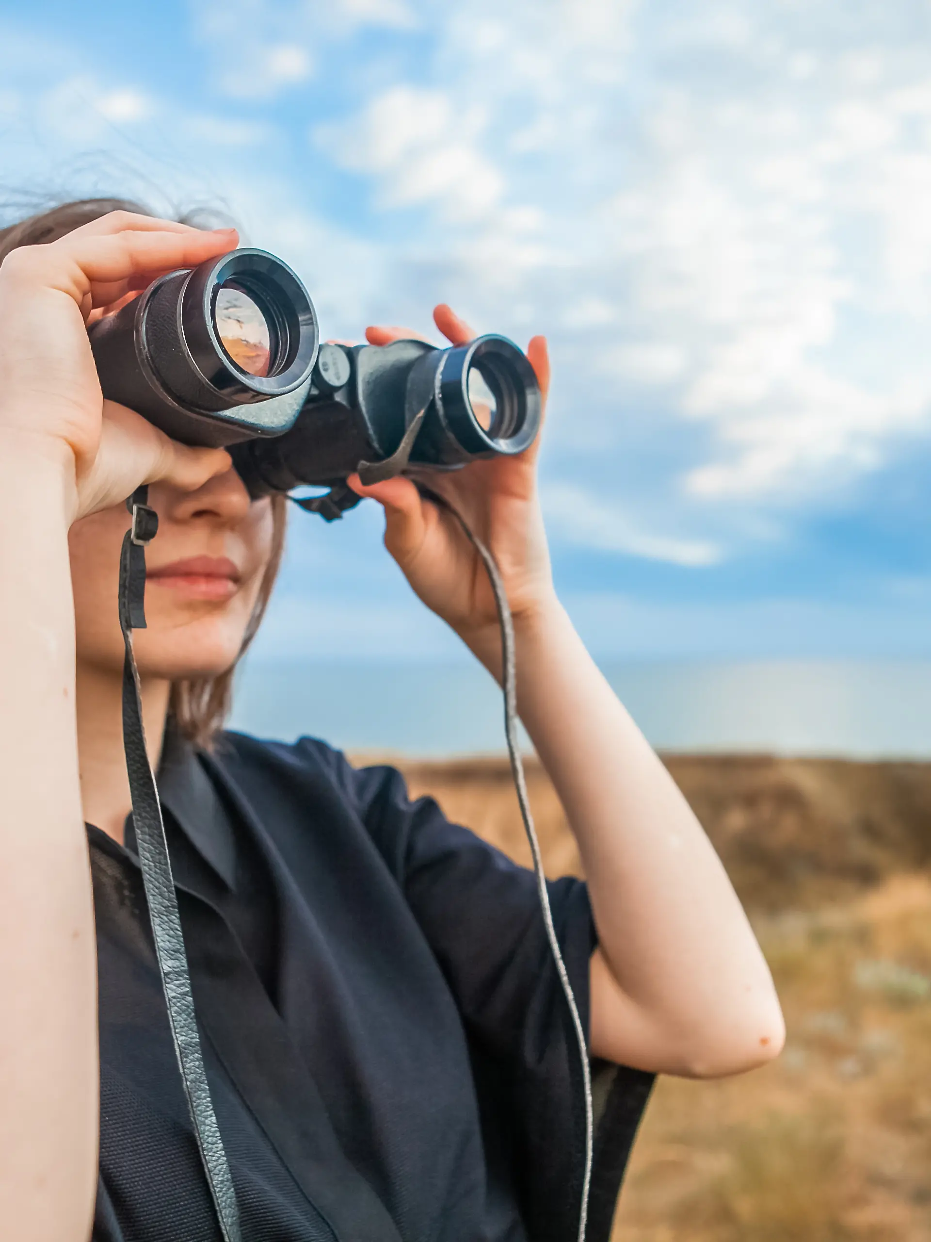 Frau schaut durch Fernglas