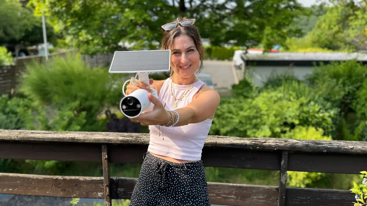 Reporterin hält Solar-Kamera in der Hand. 