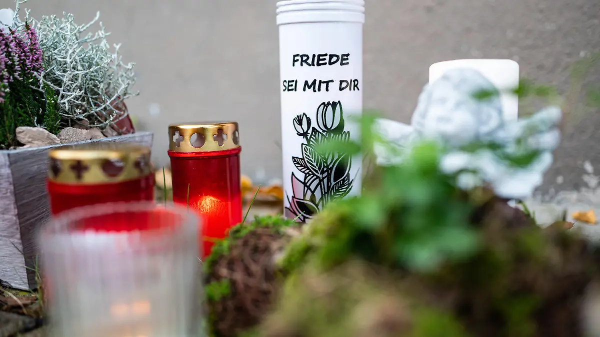 08.11.2019, Nordrhein-Westfalen, Detmold: Auf einer der Kerzen, die neben Blumen an dem Mehrfamilienhaus abgelegt wurden, wo am Abend des 06.11.2019 eine 15-Jährige ihren dreijährigen Halbbruder in Detmold mit einem Messer getötet haben soll, steht "Friede sei mit Dir". Foto: Guido Kirchner/dpa +++ dpa-Bildfunk +++
