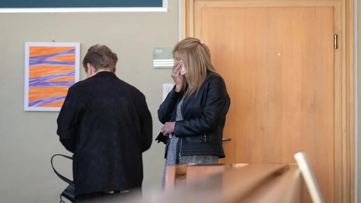 20.04.2020, Nordrhein-Westfalen, Detmold: Die Mutter (r) des getöteten Jungen steht im Landgericht Detmold, und hält sich ein Taschentuch vor das Gesicht. Mit der Anklageverlesung hat heute der Mordprozess gegen eine 15-Jährige begonnen. Die Jugendliche soll im November 2019 laut Anklage ihren dreijährigen Halbbruder mit zahlreichen Messerstichen im Schlaf getötet haben. Foto: Friso Gentsch/dpa +++ dpa-Bildfunk +++