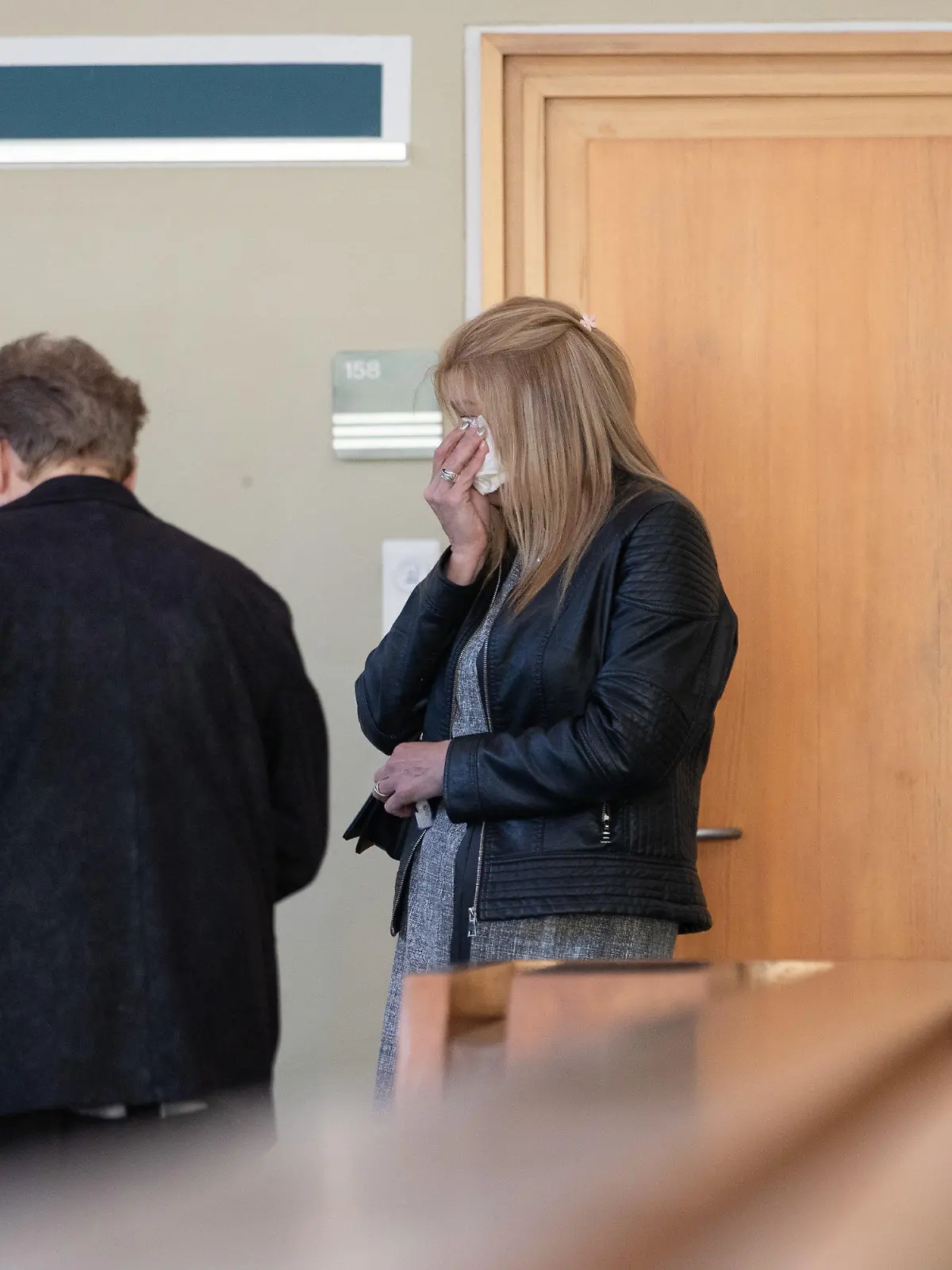 20.04.2020, Nordrhein-Westfalen, Detmold: Die Mutter (r) des getöteten Jungen steht im Landgericht Detmold, und hält sich ein Taschentuch vor das Gesicht. Mit der Anklageverlesung hat heute der Mordprozess gegen eine 15-Jährige begonnen. Die Jugendliche soll im November 2019 laut Anklage ihren dreijährigen Halbbruder mit zahlreichen Messerstichen im Schlaf getötet haben. Foto: Friso Gentsch/dpa +++ dpa-Bildfunk +++