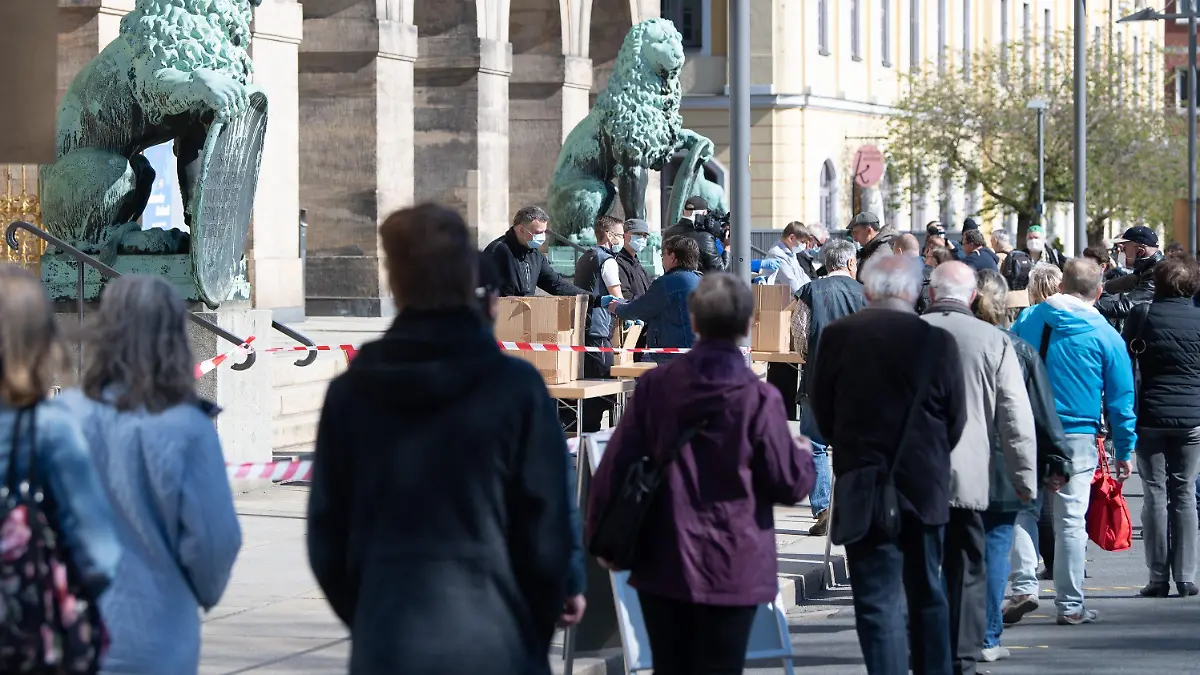 20.04.2020, Sachsen, Dresden: Mitarbeiter der Stadt Dresden verteilen vor dem Rathaus Mundschutzmasken. Insgesamt werden 200.000 Masken an Bürger verteilt, die keine eigene Möglichkeit haben, sich eine Mund-Nasen-Bedeckung zu besorgen. Foto: Sebastian Kahnert/dpa-Zentralbild/dpa +++ dpa-Bildfunk +++