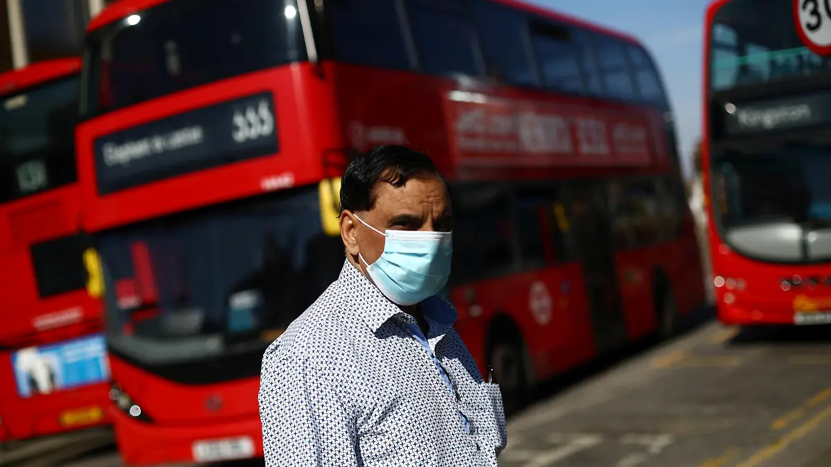 A man is seen wearing a protective face mask at a bus station as the spread of coronavirus disease (COVID-19) continues in London, Britain, April 15, 2020. REUTERS/Hannah McKay