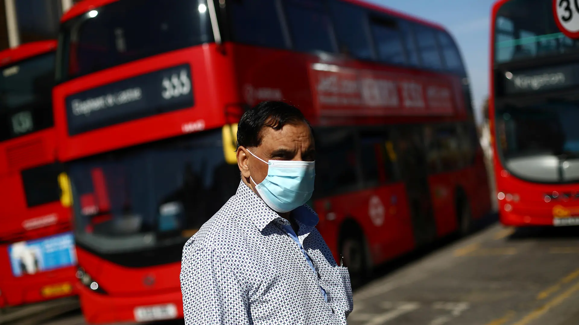 A man is seen wearing a protective face mask at a bus station as the spread of coronavirus disease (COVID-19) continues in London, Britain, April 15, 2020. REUTERS/Hannah McKay