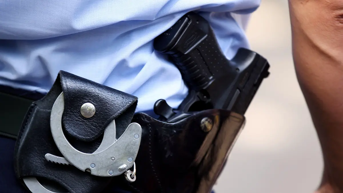 ARCHIV - 28.06.2011, Nordrhein-Westfalen, Köln: Ein Polizist trägt Handschellen und seine Dienstwaffe bei sich. Im Jahr 2022 sind in Sachsen zwei Menschen nach Schüssen aus Polizeiwaffen ums Leben gekommen. (zu dpa «Zwei Menschen 2022 nach Schusswaffeneinsatz der Polizei gestorben») Foto: Oliver Berg/dpa/Symbolbild +++ dpa-Bildfunk +++