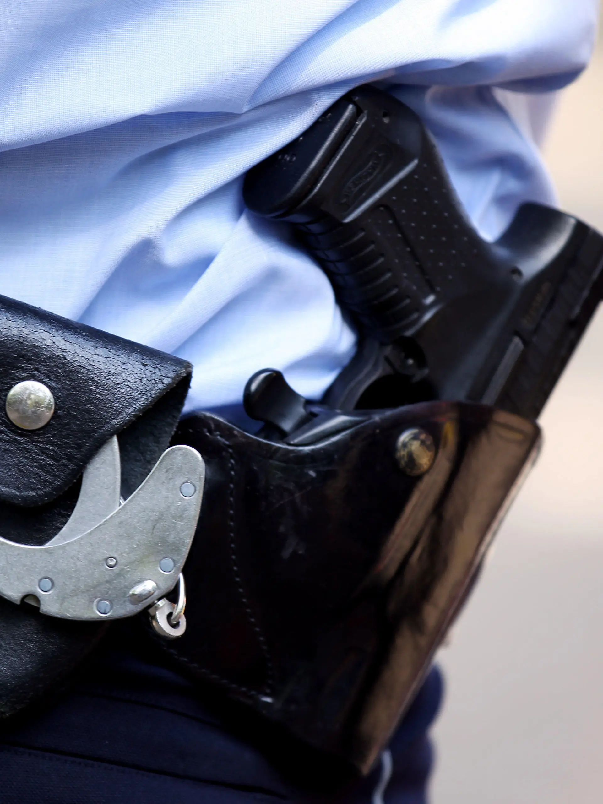 ARCHIV - 28.06.2011, Nordrhein-Westfalen, Köln: Ein Polizist trägt Handschellen und seine Dienstwaffe bei sich. Im Jahr 2022 sind in Sachsen zwei Menschen nach Schüssen aus Polizeiwaffen ums Leben gekommen. (zu dpa «Zwei Menschen 2022 nach Schusswaffeneinsatz der Polizei gestorben») Foto: Oliver Berg/dpa/Symbolbild +++ dpa-Bildfunk +++