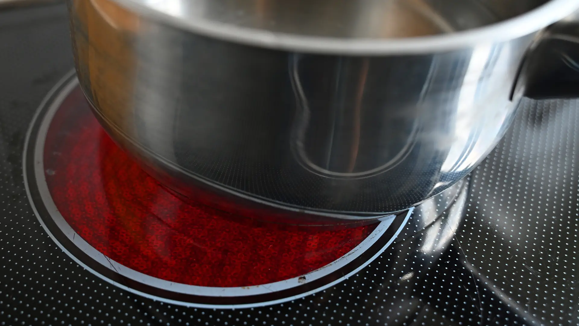 Ein Kochtopf steht auf einer beheizten Herdplatte.